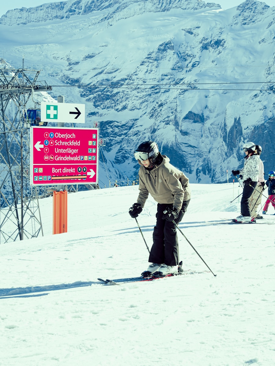 a group of people riding skis on top of a snow covered slope