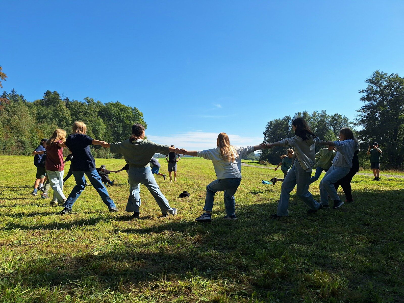 Children playing tug-of-war in a grassy field
